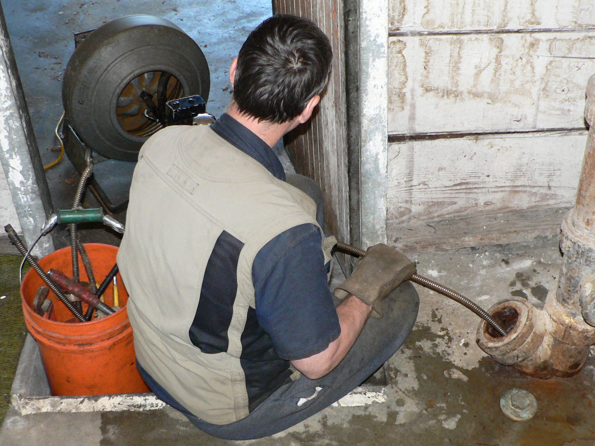 Hand-cranked plumber's snake auger used to clear a slow drain