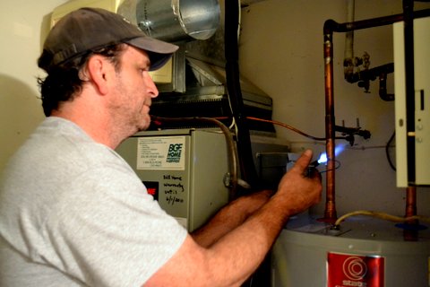 Plumber soldering pipe above a new water heater